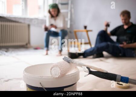 Paint roller and paint bucket in room Stock Photo