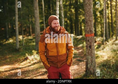 Smiling man standing in forest Stock Photo