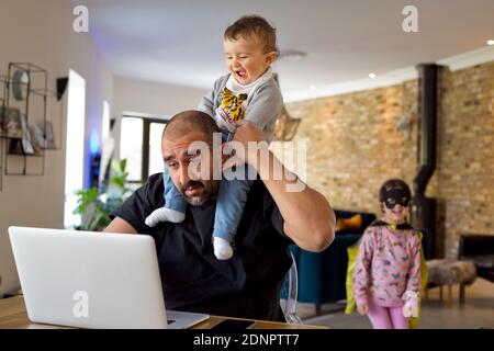 Man with children using laptop Stock Photo