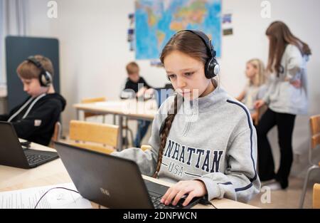 Girl in classroom using laptop Stock Photo