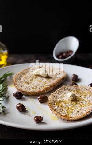 High Angle View Of Bread With Rosemary In Plate On Table Against Black Background