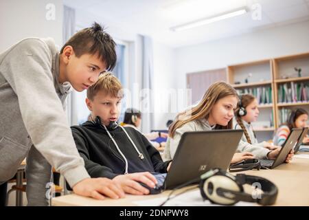 Boys in classroom using laptop Stock Photo