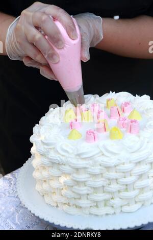 Person decorating cake in a pastry shop Stock Photo