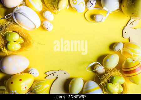 Easter egg and Easter bunny decorations arranged on a yellow background Stock Photo