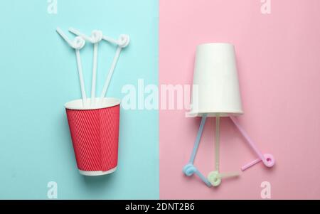 Two paper coffee cup with cocktail straws on a colored pastel background, top view, minimalism. Stock Photo
