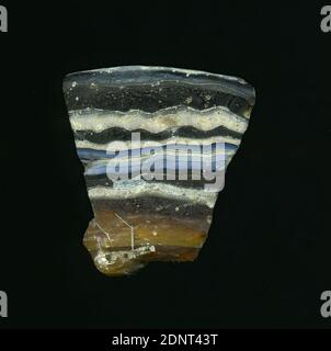 Fragment of a vessel, glass, pressed, cut, Total: Height: 4.00 cm; Width: 3.90 cm; Depth: 0.60 cm, container, storage, kitchen work, Early Imperial Period, A slight curvature and the preserved edge of the glass fragment allow the assignment to a vessel, possibly a bowl. The dark to light brown glass is interspersed on the outside with white and blue horizontal stripes. Inside there are three white stripes. For the production different colored glasses were formed into tubes and rods. These were pressed together and heated. Stock Photo