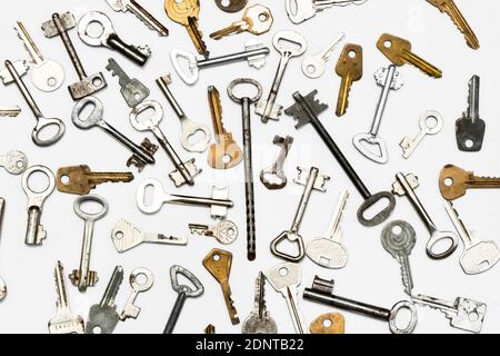 Keys to the locks. Many different keys to the locks lie on a white surface Stock Photo