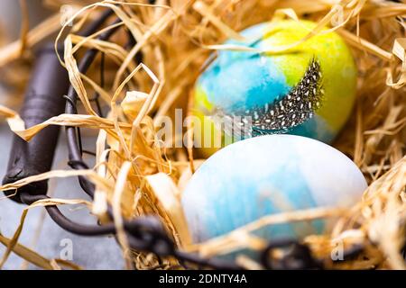 Multi coloured Easter eggs in a basket surrounded with straw Stock Photo
