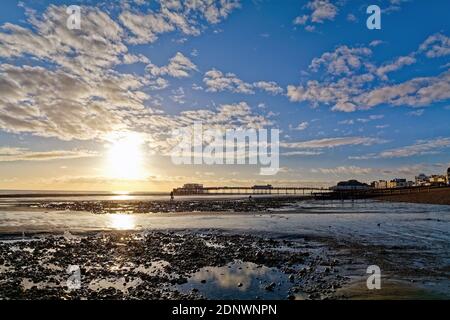 The pier at Worthing against a dramatic winter sunset and clouds west Sussex England UK Stock Photo