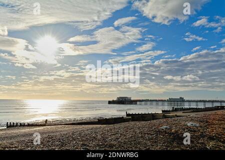 The pier at Worthing against a dramatic winter sunset and clouds west Sussex England UK Stock Photo