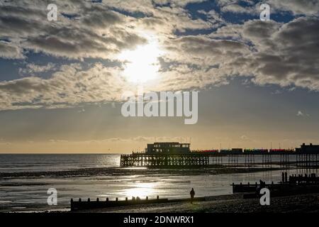 The pier at Worthing against a dramatic winter sunset and clouds west Sussex England UK Stock Photo