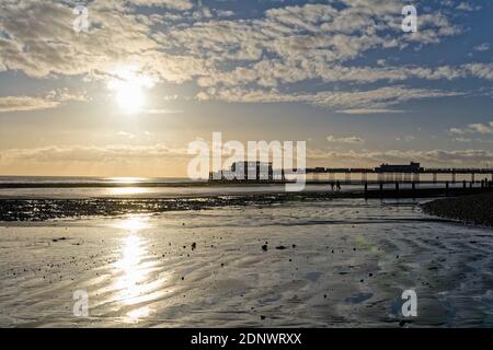 The pier at Worthing against a dramatic winter sunset and clouds west Sussex England UK Stock Photo