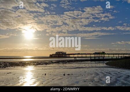 The pier at Worthing against a dramatic winter sunset and clouds west Sussex England UK Stock Photo