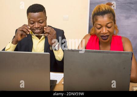 Teamwork: businessman and businesswoman working in office, they discuss and work on laptop. Stock Photo