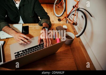 mixed race businessman typing on laptop sitting at desk in home office  Stock Photo