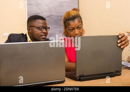 Teamwork: businessman and businesswoman working in office, they discuss and work on laptop. Stock Photo