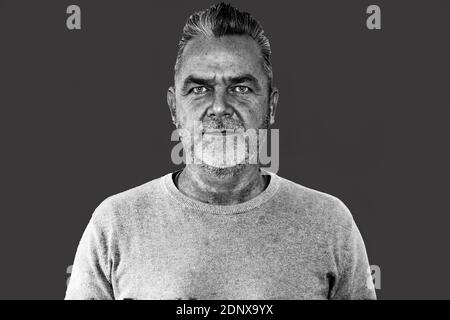 Middle aged man with modern hairstyle  looking at the camera with a serious expression in black and white Stock Photo
