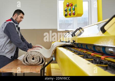 Man operating carpet automatic washing machine in professional laundry service Stock Photo