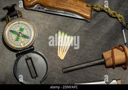EDC. Wearable set for survival and tourism. Folding knife, compass and hunting matches with flint. Every Day Carry. Stock Photo