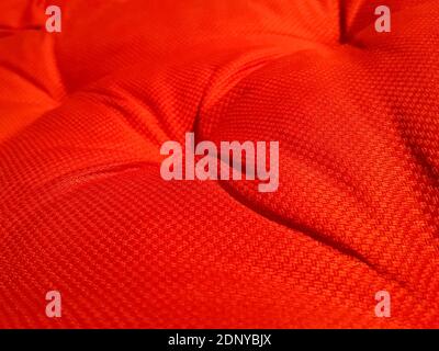 Red soft wrinkled cloth of the cushion or sofa as background Stock Photo