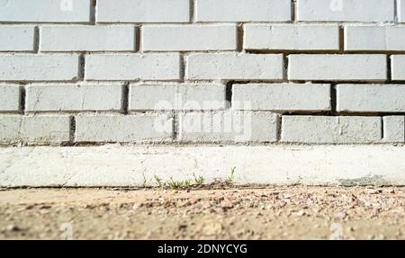 White brick wall and ground with grass - outdoor exterior Stock Photo