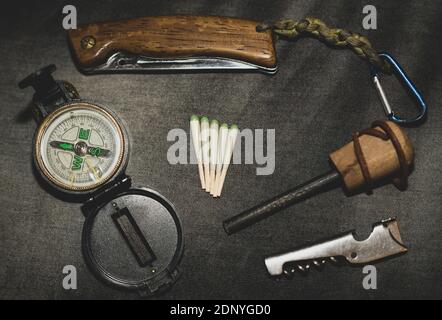bushcraft starting equipment. EDC. Wearable set for survival and tourism. Folding knife, compass and hunting matches with flint. Every Day Carry Stock Photo