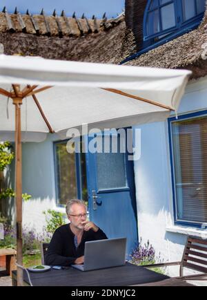 Man using laptop in garden Stock Photo