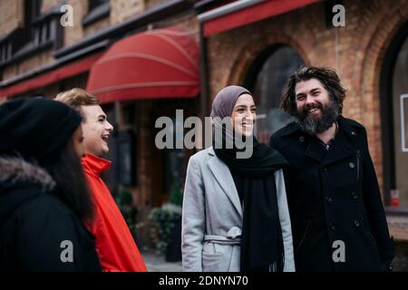 Group of friends walking on street and laughing Stock Photo