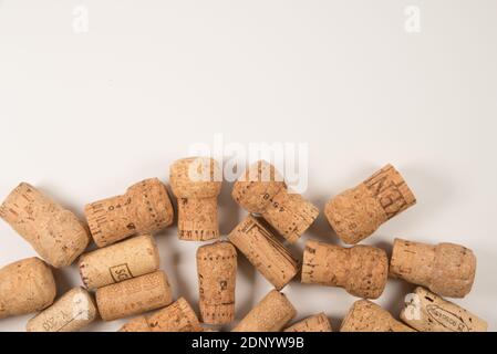 Used wine corks scattered randomly fill half frames on white background, space for text, isolated on white  top view Stock Photo