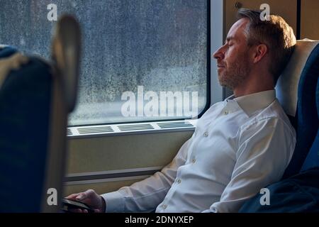 Man sleeping in train Stock Photo