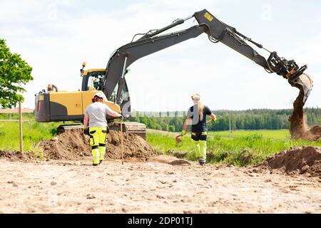 Female workers with digger on background Stock Photo
