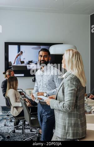 Coworkers talking in boardroom Stock Photo