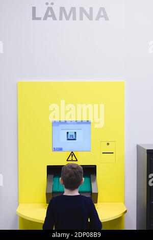 Boy using self service point in library Stock Photo