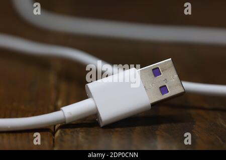 USB cable for charging the phone on a blurred background. Stock Photo