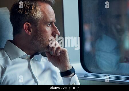 Man looking through train window Stock Photo