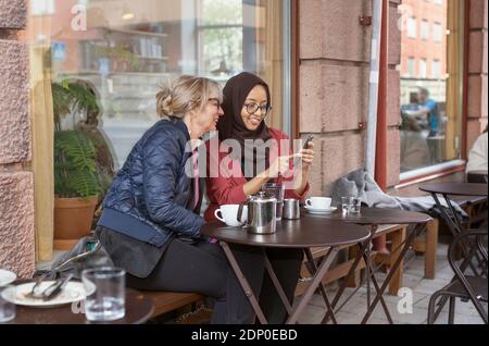 Women sitting together in outdoor cafe Stock Photo