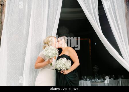 Brides kissing at wedding Stock Photo