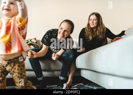 Female couple sitting on sofa Stock Photo