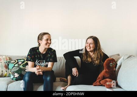 Female couple sitting on sofa Stock Photo