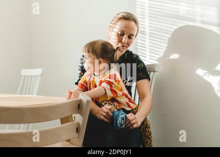 Daughter sitting on mothers lap Stock Photo