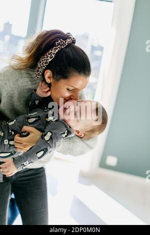 Mother carry toddler son sitting at table Stock Photo