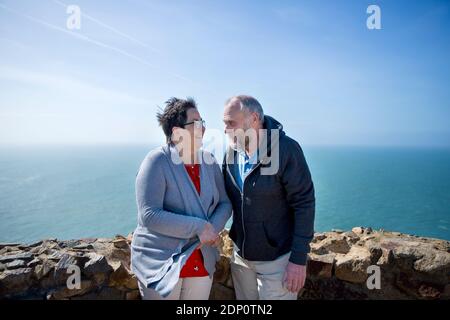 Smiling couple standing together, sea on background Stock Photo