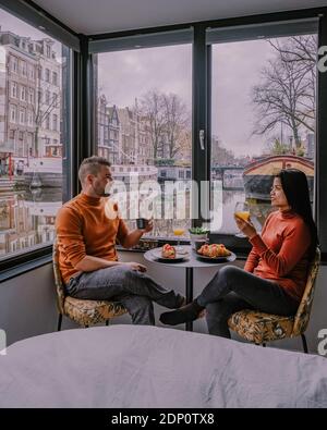 Amsterdam dutch canals , couple visit dutch canals during city trip in Amsterdam, men and woman on city trip in Amsterdam Netherlands. Europe Stock Photo