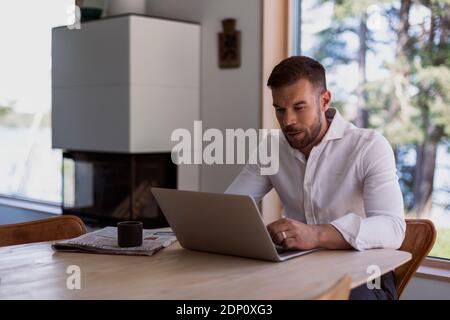 Man at home using laptop Stock Photo
