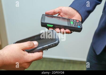 Two Man Pairing Handheld Mobile Computers Stock Photo