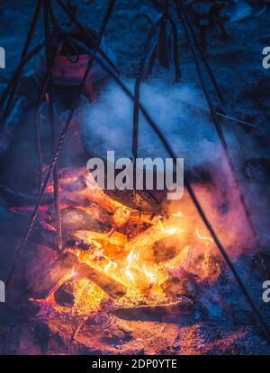 Selective focus on boiling cauldron with mysterious decoction on a campfire at night witch sabbath. Kupala Night, called in Poland Noc Kupaly, Cedynia Stock Photo
