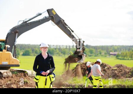 Female worker with digger on background Stock Photo