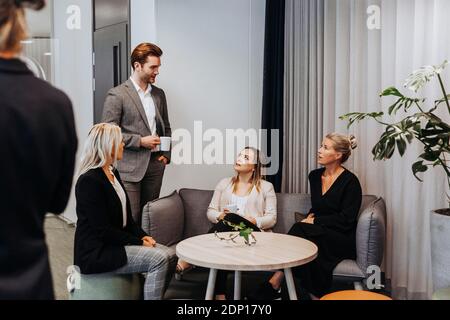 Coworkers talking during coffee break Stock Photo
