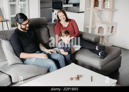 Parents with daughter on sofa Stock Photo