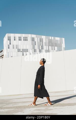 Young man wearing black kaftan standing outdoors Stock Photo